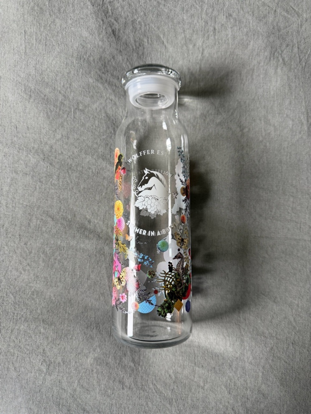 Wolffer Estate Clear Glass Water Bottle with Colorful Floral Graphics
